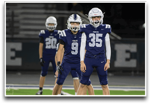 Three football players are standing on the field, one of them is smiling and wearing a black jersey with the number 55. AI generated content