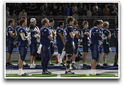 Three football players are standing on the field, one of them is smiling and wearing a black jersey with the number 55. AI generated content