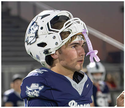 A football player wearing a blue and white uniform. Description generated by AI