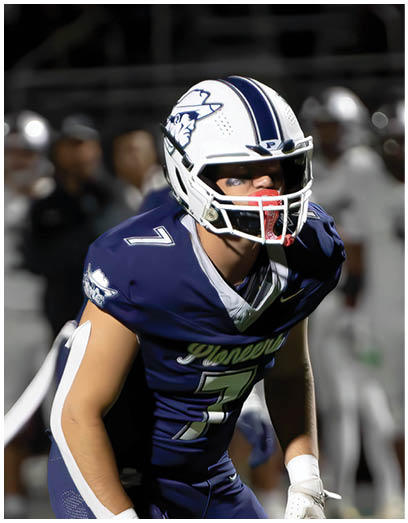 A football player wearing a blue and white uniform. Description generated by AI