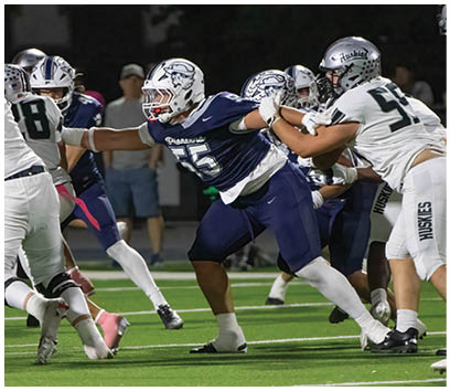 A football player wearing a blue and white uniform. Description generated by AI