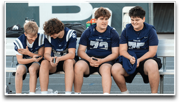 Three football players are standing on the field, one of them is smiling and wearing a black jersey with the number 55. AI generated content