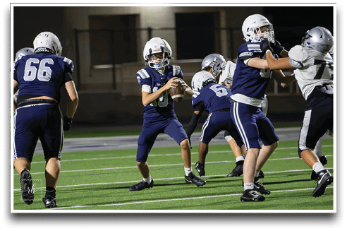 Three football players are standing on the field, one of them is smiling and wearing a black jersey with the number 55. AI generated content