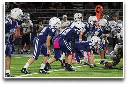 Three football players are standing on the field, one of them is smiling and wearing a black jersey with the number 55. AI generated content