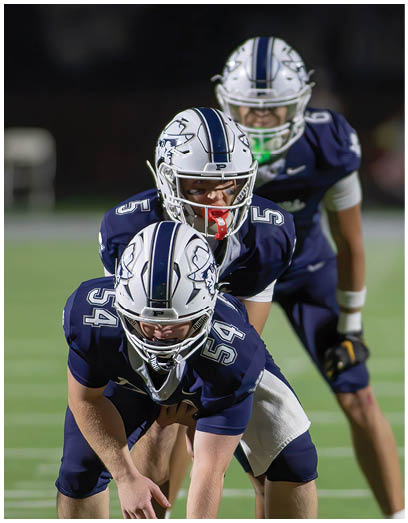A football player wearing a blue and white uniform. Description generated by AI
