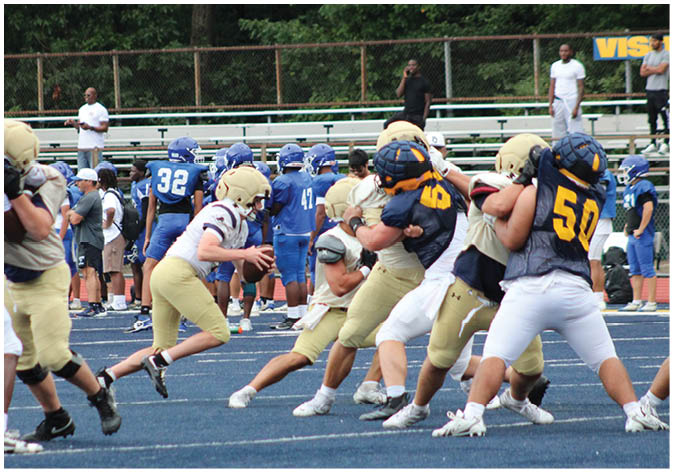 A group of football players wearing black and white uniforms. Description generated by AI
