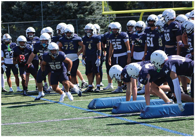 A group of football players wearing black and white uniforms. Description generated by AI