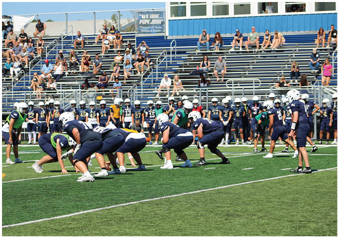 A group of football players wearing black and white uniforms. Description generated by AI