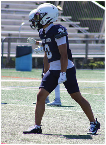 A football player wearing a blue jersey with the number 58 on it. Description generated by AI