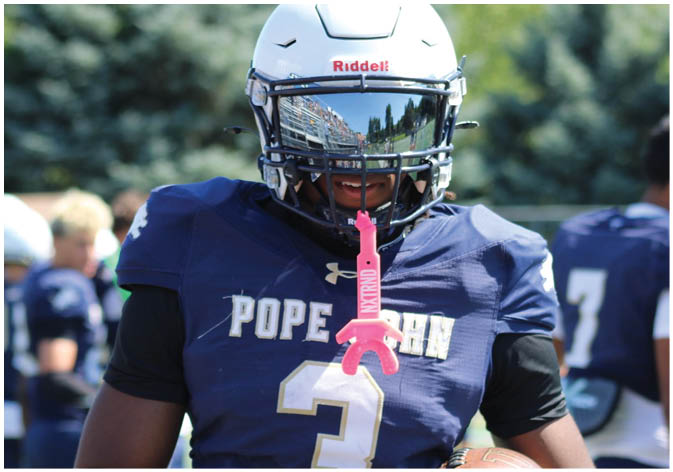 A group of football players wearing black and white uniforms. Description generated by AI