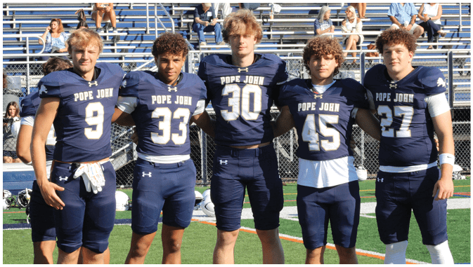 A group of football players on a field. Description generated by AI
