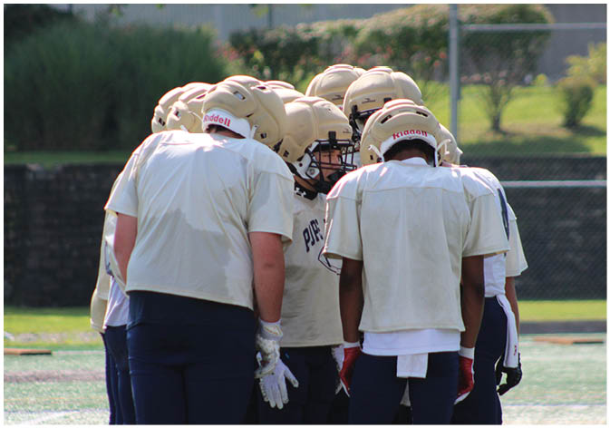 A group of football players wearing black and white uniforms. Description generated by AI