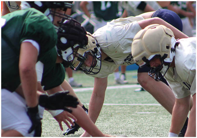 A group of football players wearing black and white uniforms. Description generated by AI