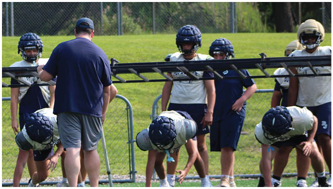 A group of football players on a field. Description generated by AI