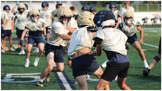 A group of football players on a field. Description generated by AI
