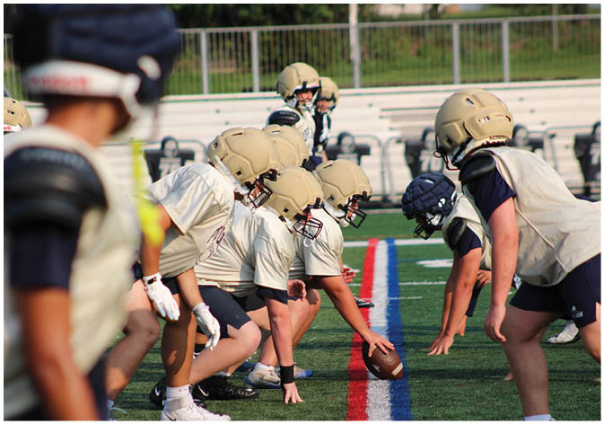 A group of football players wearing black and white uniforms. Description generated by AI