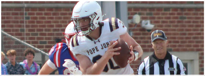 A football game is taking place on a field with players wearing blue and white uniforms. Description generated by AI