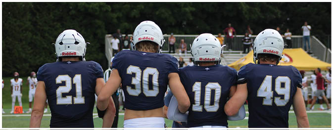 A group of football players on a field. Description generated by AI