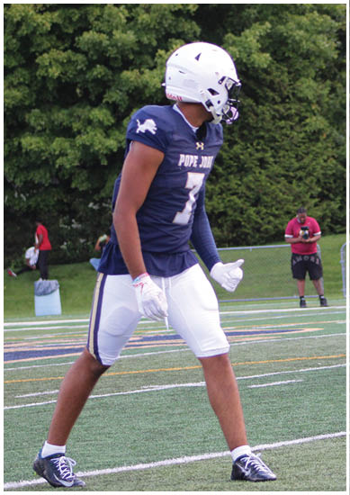 A football player wearing a blue and red jersey. Description generated by AI