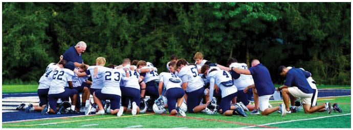 A football player wearing a blue and white uniform. Description generated by AI