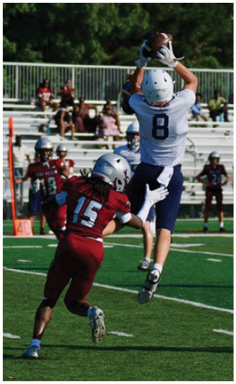A football player catching a ball. Description generated by AI