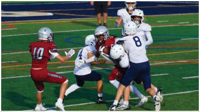 Three football players in blue and white uniforms running on a field. Description generated by AI