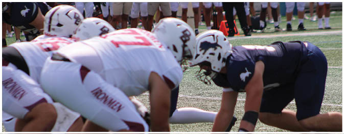 A group of football players on a field. Description generated by AI