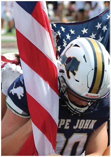 A football player wearing a blue and red jersey. Description generated by AI
