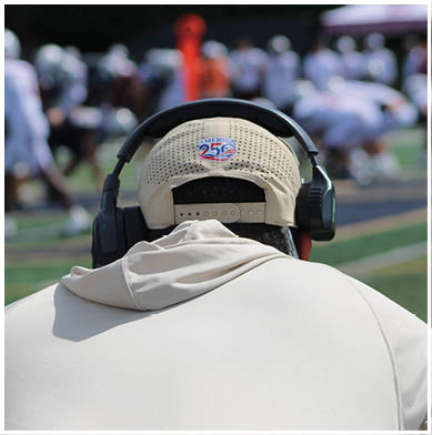 A football game is taking place with a group of men on the field. Description generated by AI