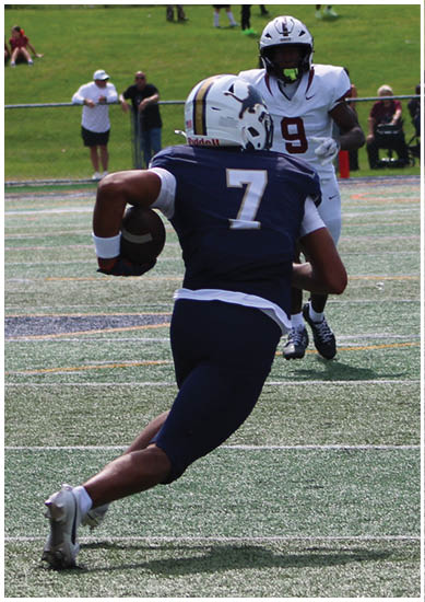 A football player wearing a blue and red jersey. Description generated by AI