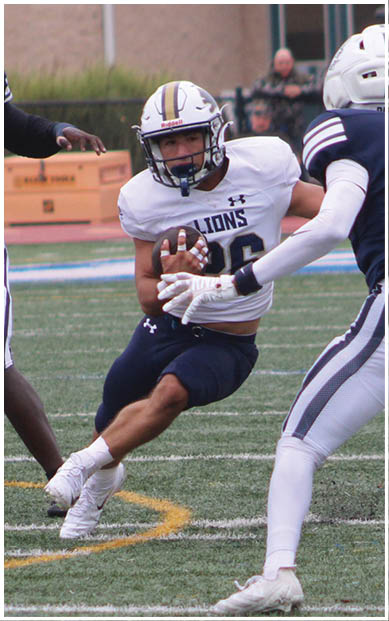 A football player wearing a blue and red jersey. Description generated by AI