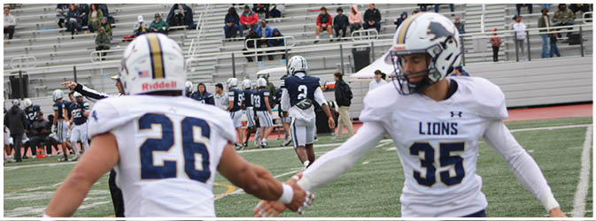 A football game is taking place on a field with players wearing blue and white uniforms. Description generated by AI