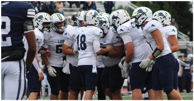 A group of football players on a field. Description generated by AI