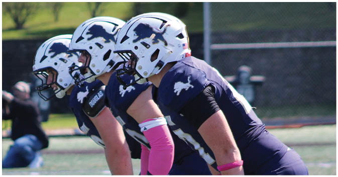 A group of football players on a field. Description generated by AI