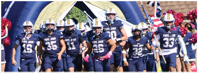 A football game is taking place on a field with players wearing blue and white uniforms. Description generated by AI