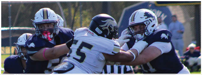 A football game is taking place on a field with players wearing blue and white uniforms. Description generated by AI