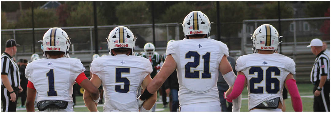 A football game is taking place on a field with players wearing blue and white uniforms. Description generated by AI