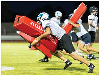 A group of football players on a field. Description generated by AI