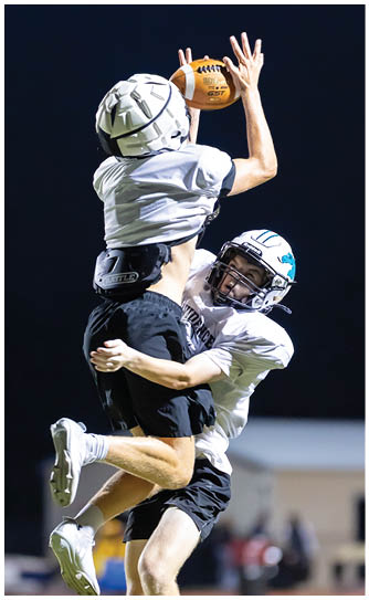 A football player catching a ball. Description generated by AI