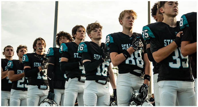 A group of football players on a field. Description generated by AI