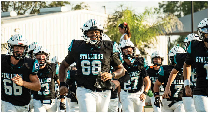 A group of football players on a field. Description generated by AI