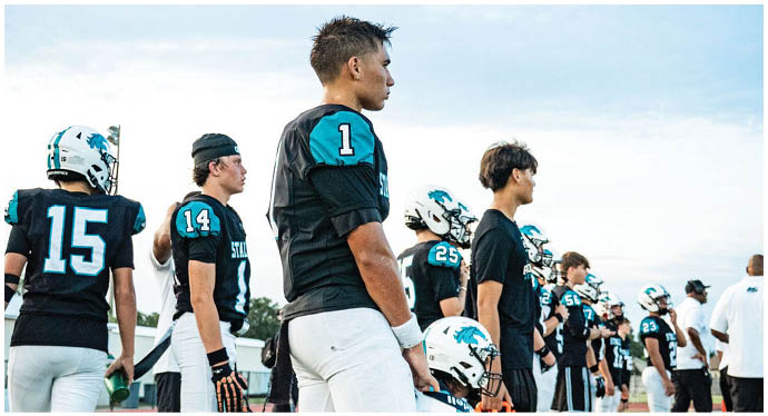 A group of football players on a field. Description generated by AI