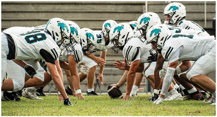 A group of football players on a field. Description generated by AI