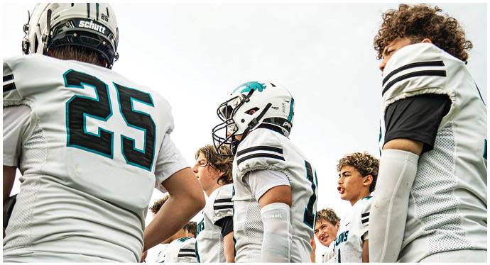 A group of football players on a field. Description generated by AI