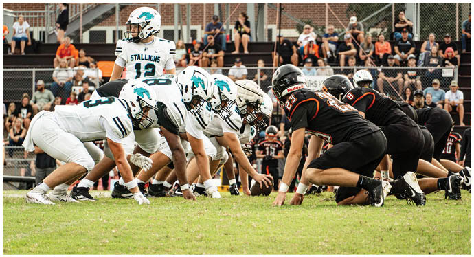 A group of football players on a field. Description generated by AI