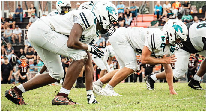 A group of football players on a field. Description generated by AI