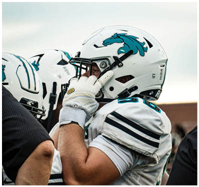A group of football players on a field. Description generated by AI