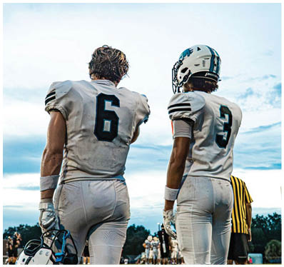 A group of football players on a field. Description generated by AI