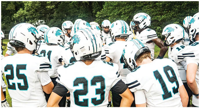A group of football players on a field. Description generated by AI