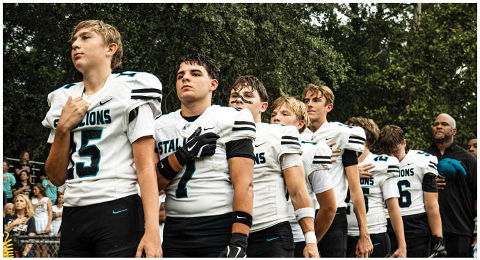 A group of football players on a field. Description generated by AI